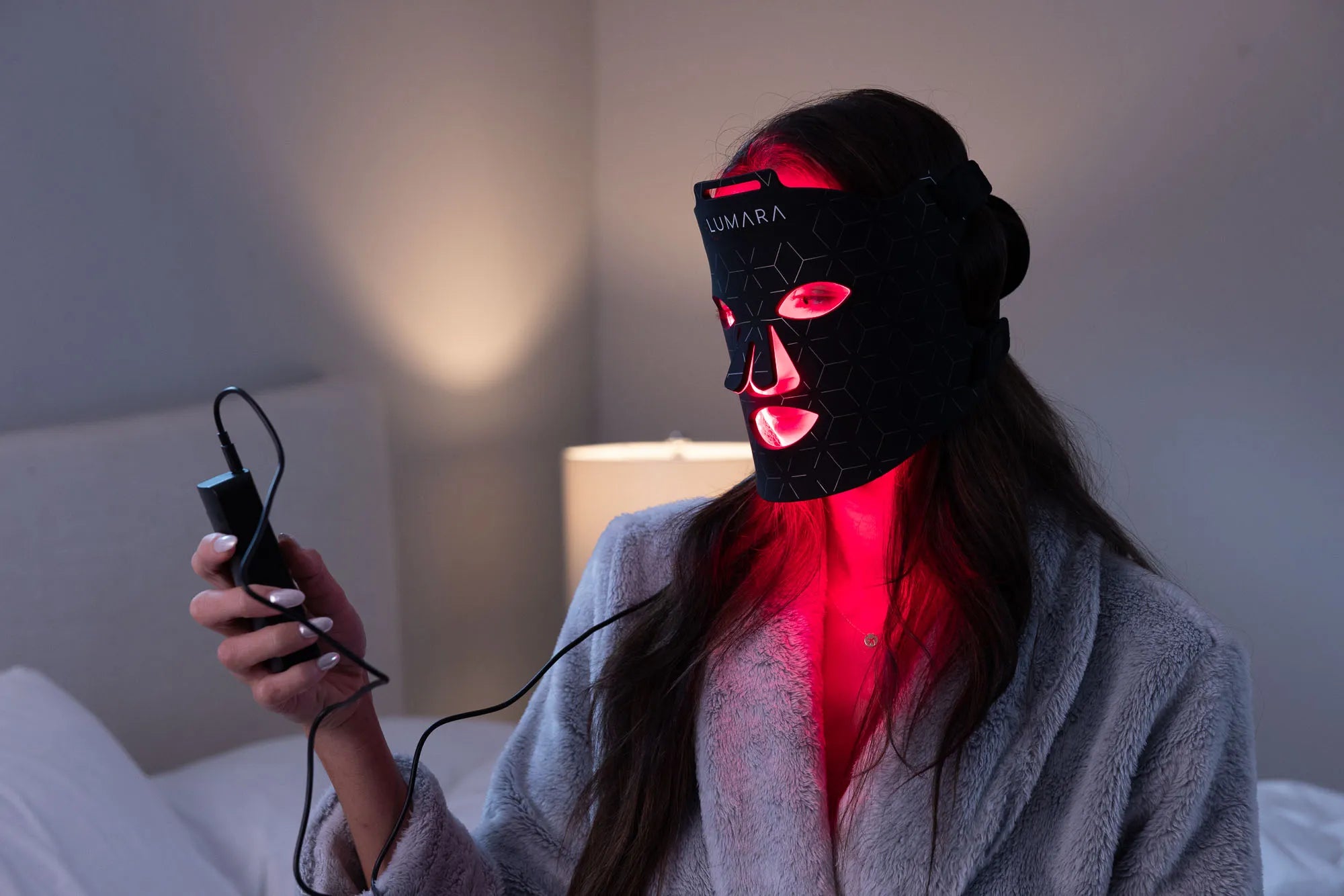 Person wearing a red LED face mask while seated