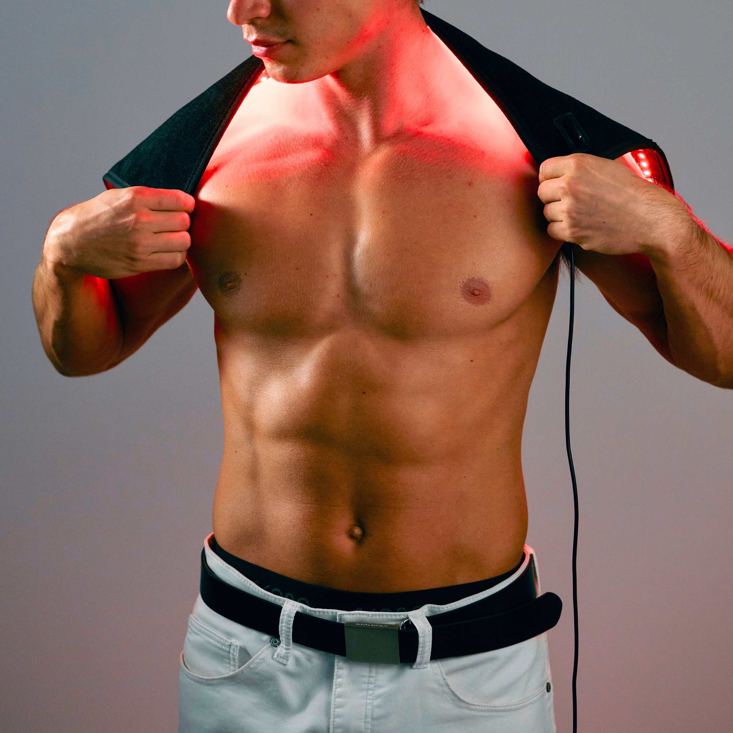 Person using a red LED therapy pad on their lower back