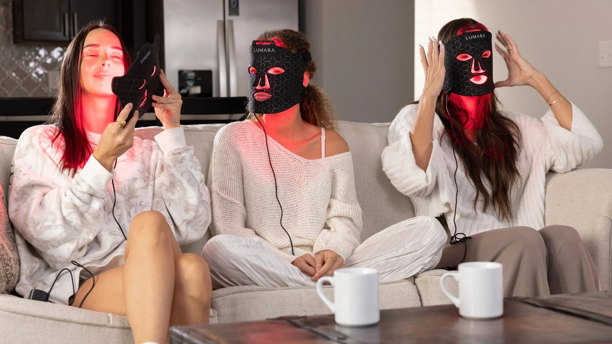 Three women relaxing while wearing Lumara red LED face masks
