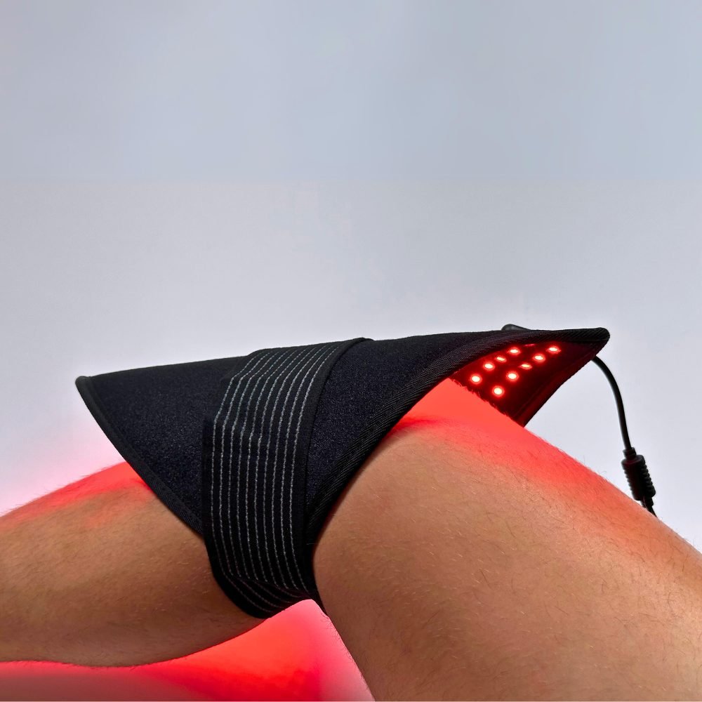 Red LED therapy pad wrapped around a person's knee